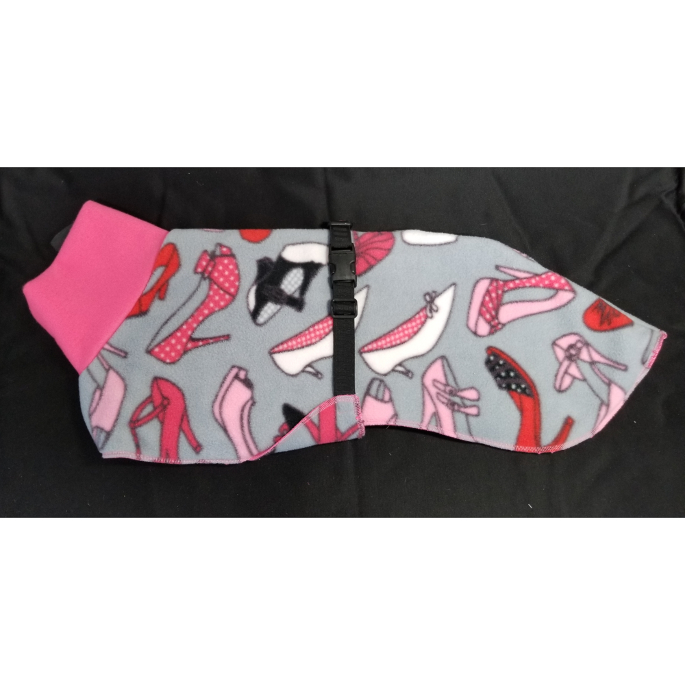 FC3277 at1000 "The coat is generous, covering the hindquarters for warmth. A breast piece comes through the front legs and protects the entire chest area - great if your dog is curled up in a crate waiting for you. Fleece inside and out keeps your dog warm and toasty in nasty weather. The collar is also fleece. Two sizes are available - Medium and Large. The medium fits most whippets up to 32 pounds. The larger coat is for the males, or a girl with a longer body. It fits whippets up to 45 pounds. And a big bonus is that fleece is easy to care for – machine wash and dry. "